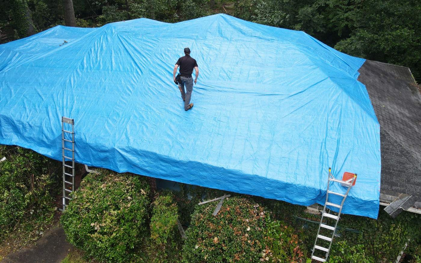 Blue emergency tarp secured on a storm-damaged roof in Atlanta