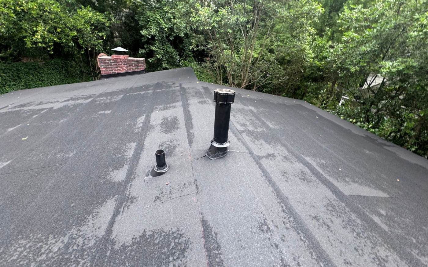 A finished modified bitumen roof on an Atlanta home, with new pipe boots set into the cap sheet.