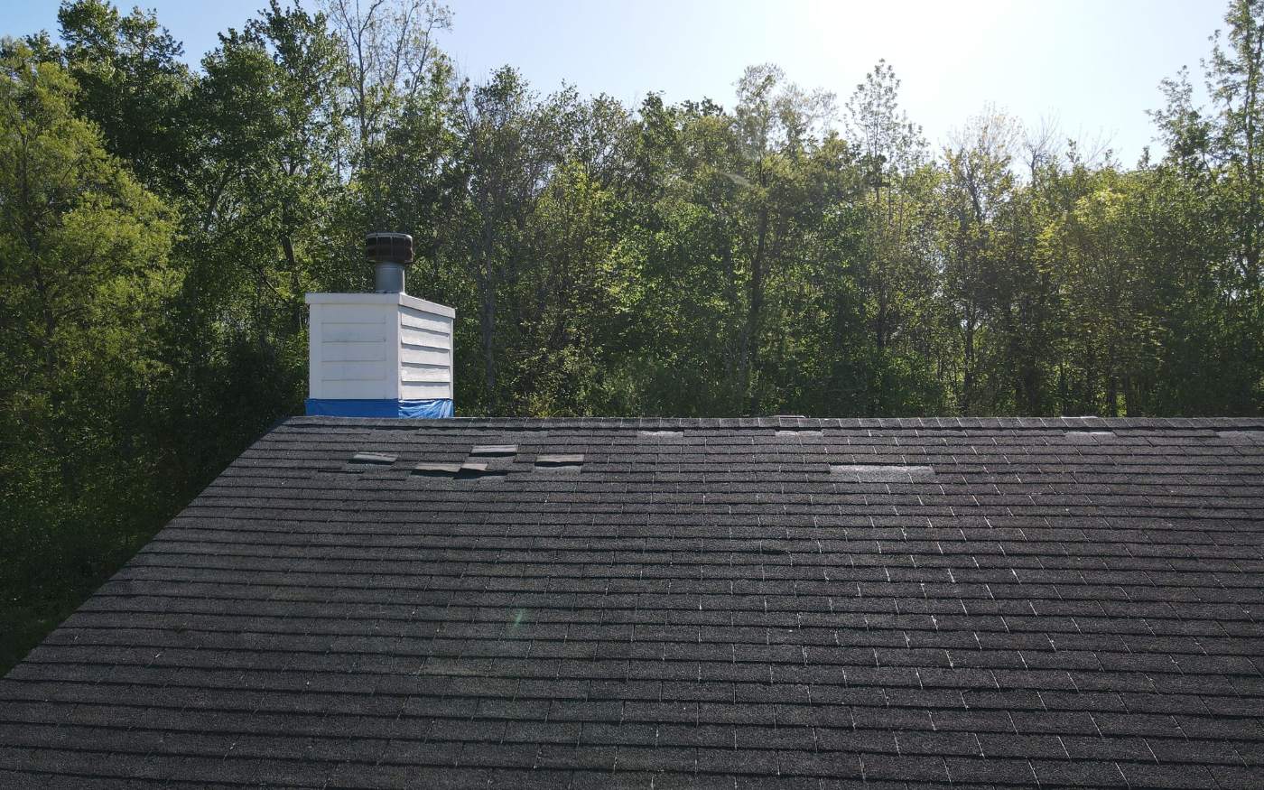 New shingles and chimney flashing after a roof repair.