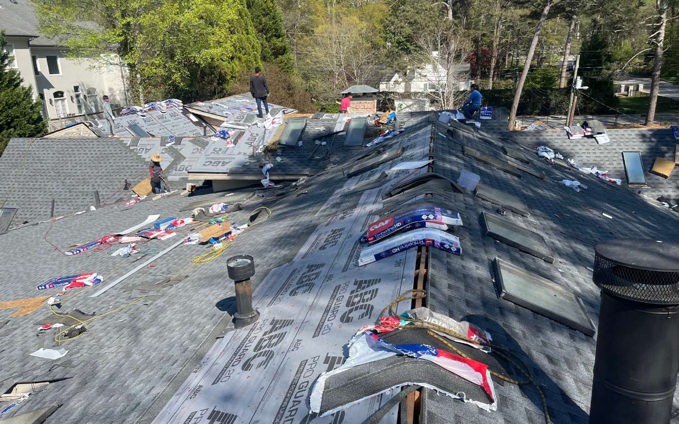 Aerial view of a roof replacement in progress with new underlayment going down