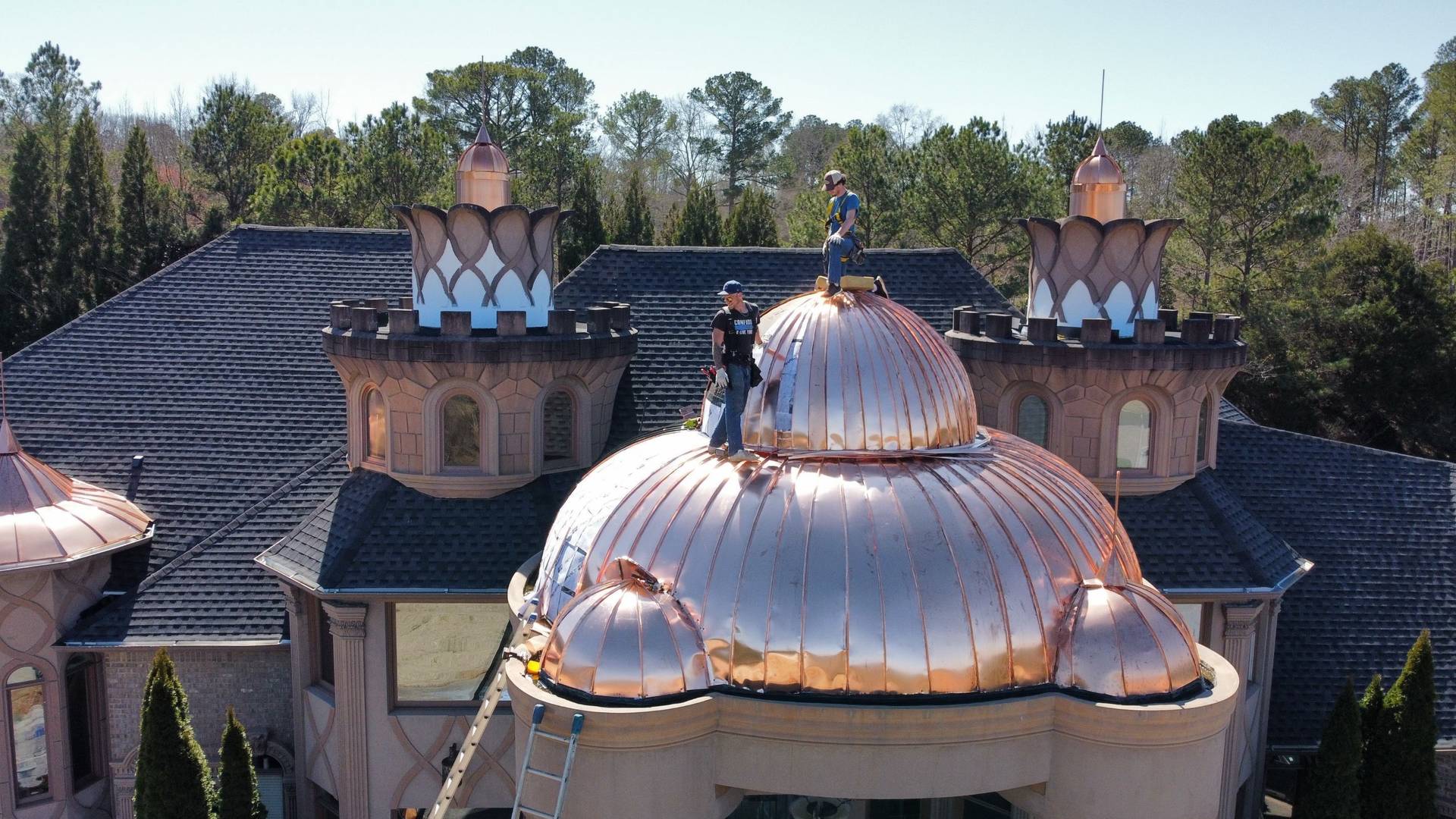 Standing seam copper dome being installed by hand on a luxury home