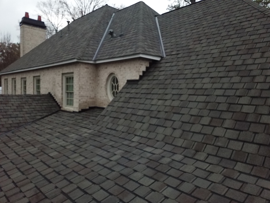 Slate-profile designer shingles on a brick traditional home, with metal-lined valleys and stepped brick sidewalls.