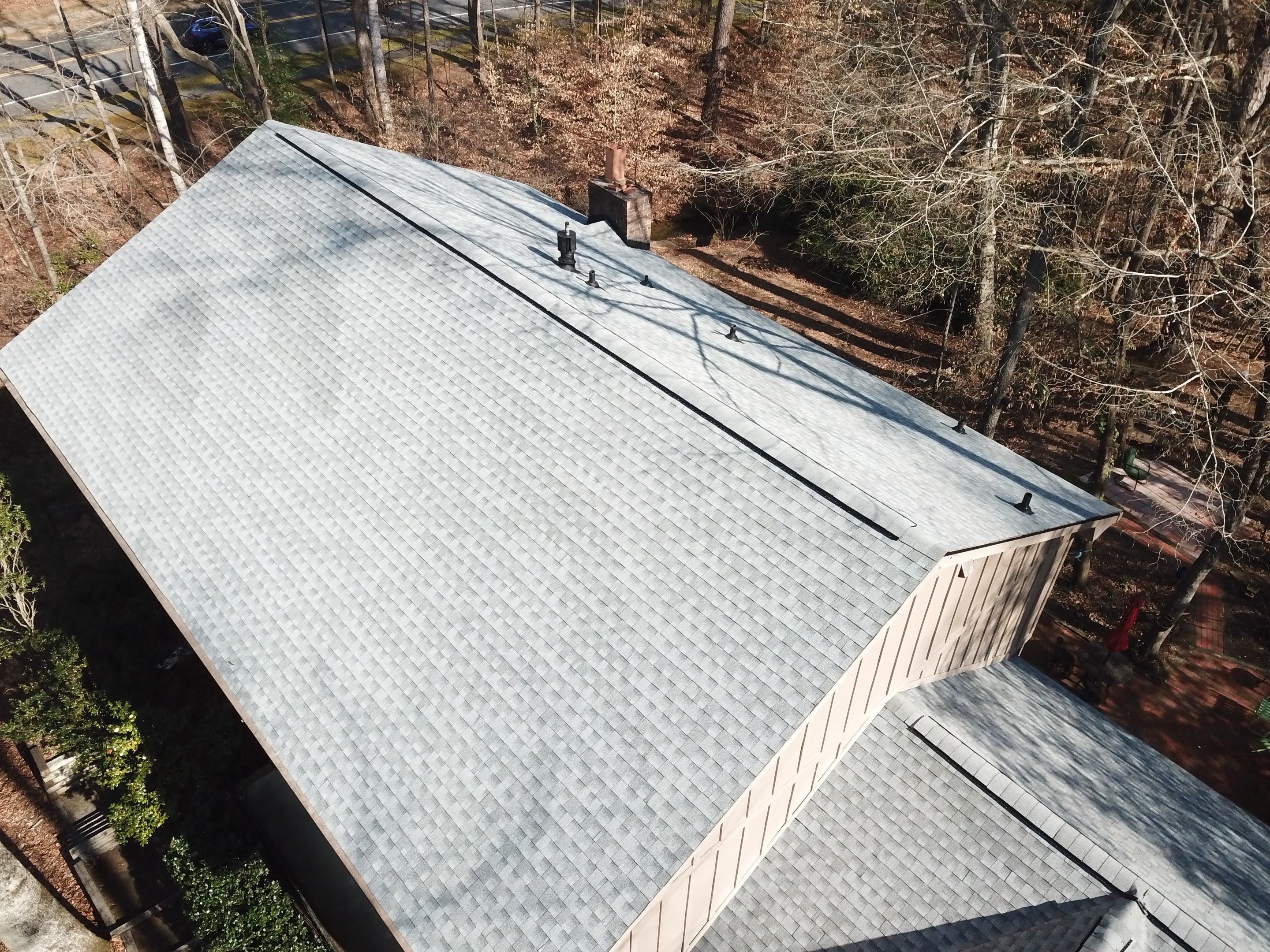 Aerial drone view of completed roof replacement at the Lawson Herron home in Roswell, light gray architectural shingles