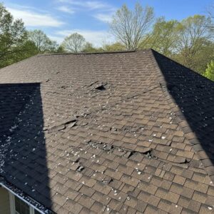 Hail damage on a residential roof in Atlanta, showcasing dents and granule loss